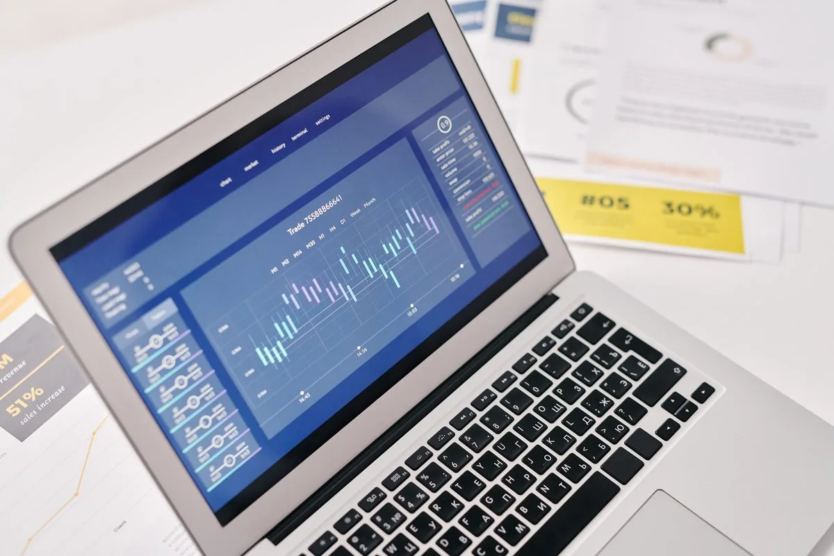 Notebook com tela exibindo gráfico de desempenho e dados de negócio