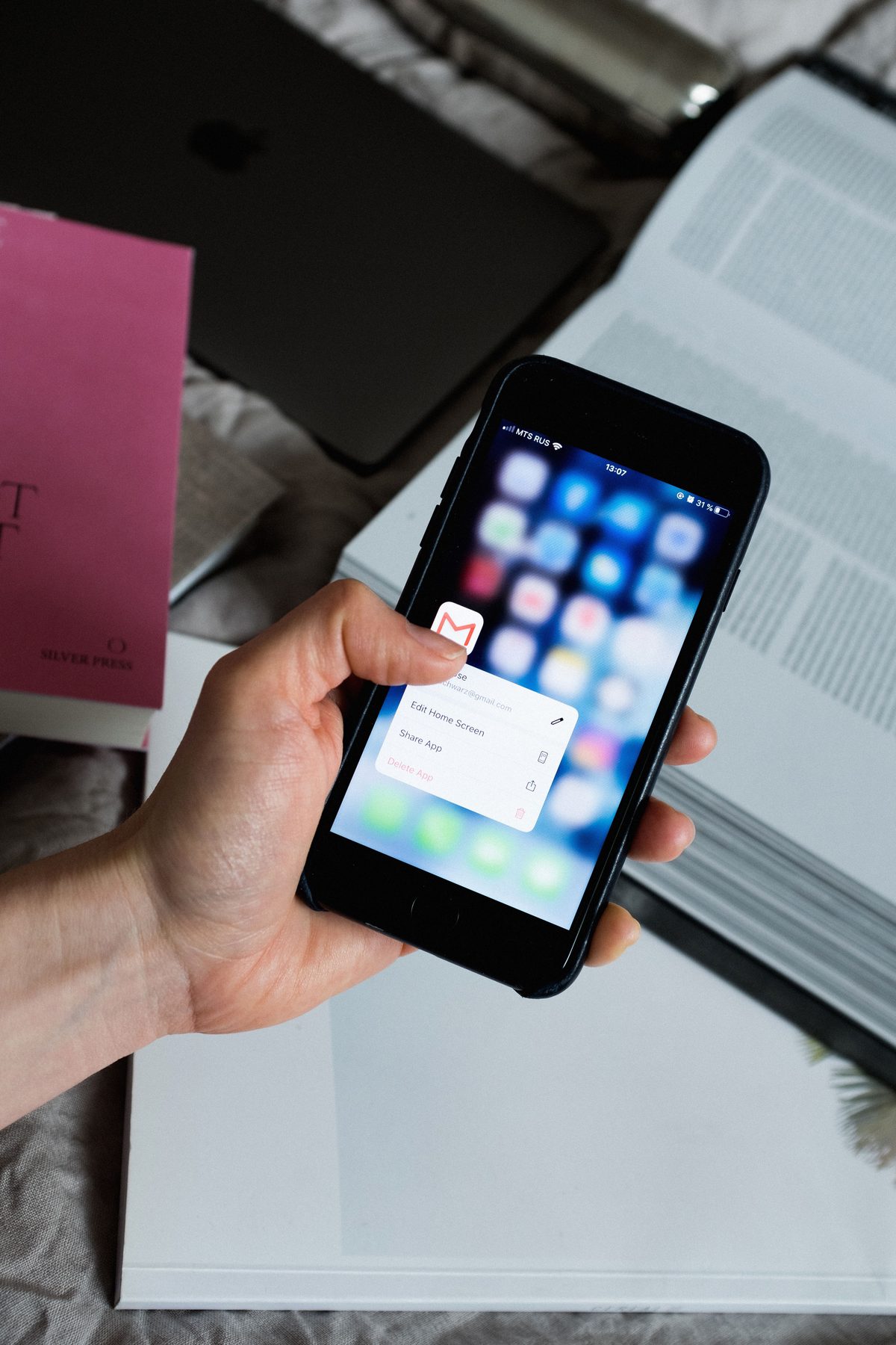 Mão segurando smartphone com ícone de e-mail em destaque na tela
