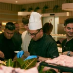 Chef e equipe de prestadores de serviço preparando e servindo um buffet de evento
