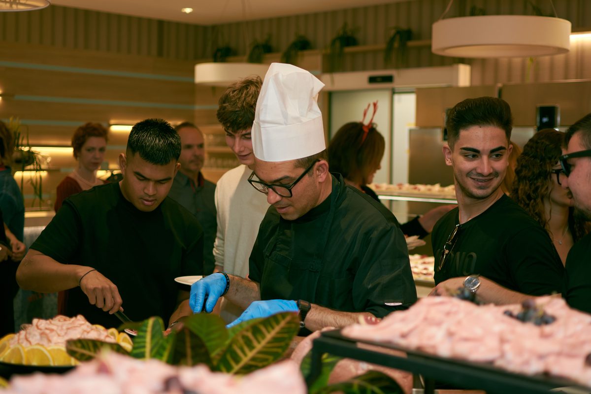 Chef e equipe de prestadores de serviço preparando e servindo um buffet de evento