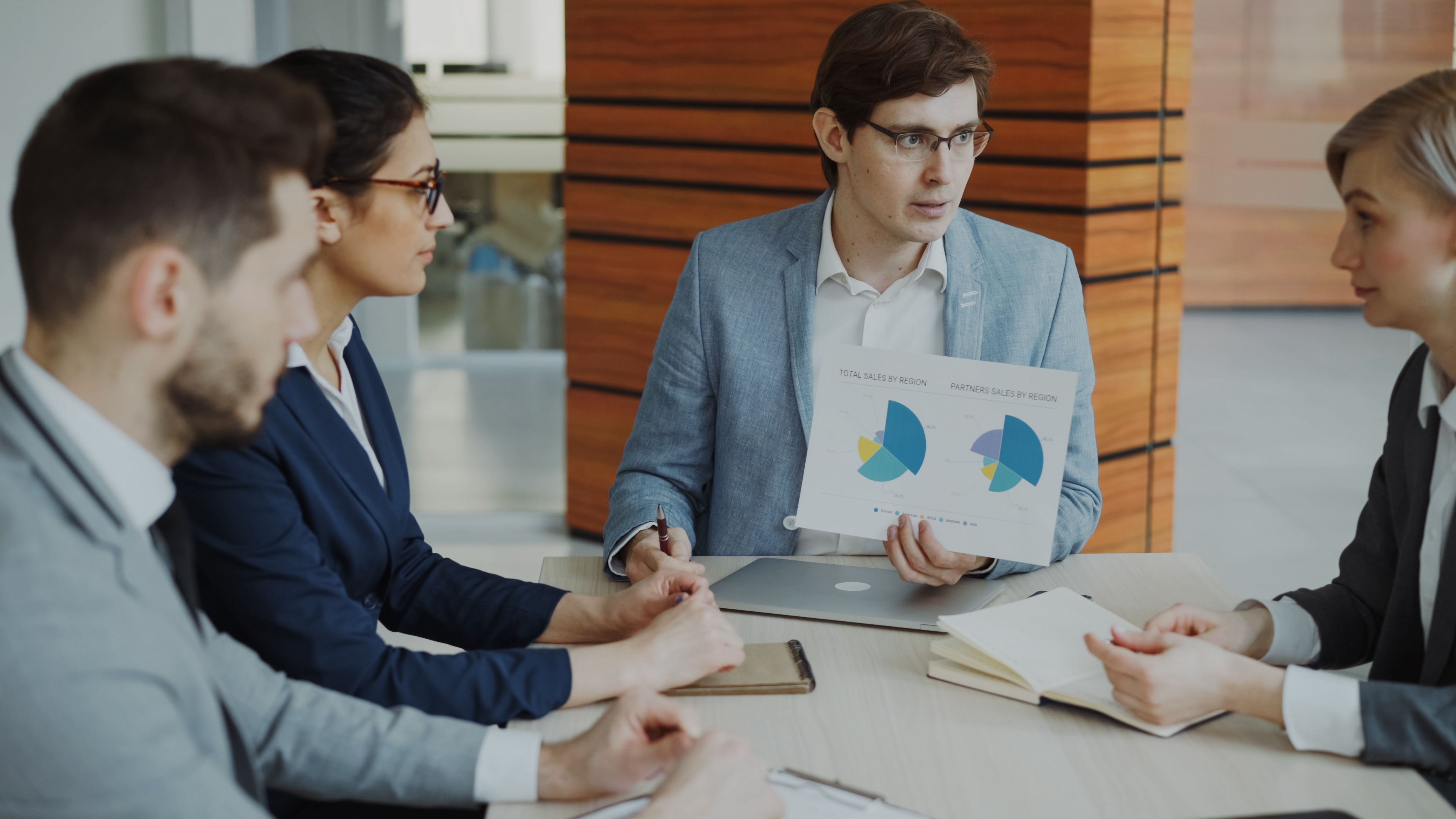 Equipe em reunião analisando dados antes de decidir, representando escolha estratégica de sistema de gestão