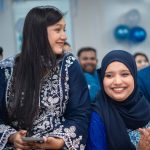 Convidadas sorrindo e aplaudindo durante uma festa, representando a satisfação do público em um evento